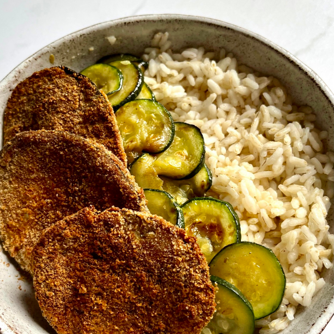 Piatto con melanzane croccanti, zucchine e riso